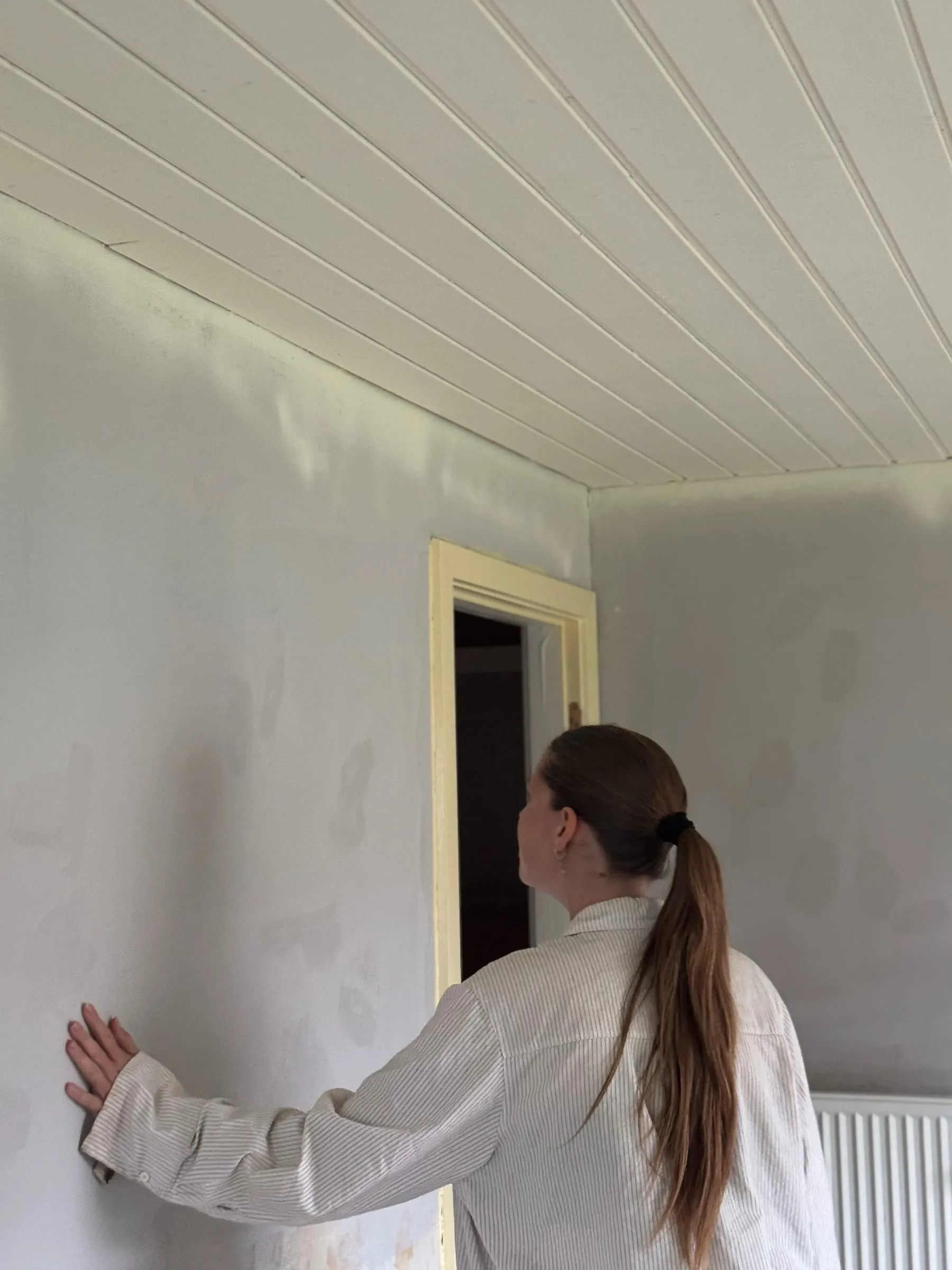 Sarah Tarp gennemgår en væg i en bolig under renovering